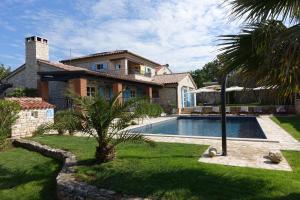 a house with a swimming pool in front of a house at Villa Emma Smoljanci 76 in Svetvinčenat