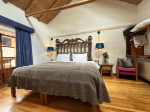 a bedroom with a large bed and a chair at ARQUEOLOGO EXCLUSIVE SELECTION - Casa Peralta in Cusco