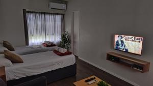 a room with two beds and a flat screen tv at Studio Soho 53 in La Plata
