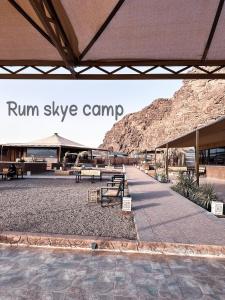 un cartello di un campo scintillante di corsa davanti a un edificio di Rum Skye camp a Wadi Rum
