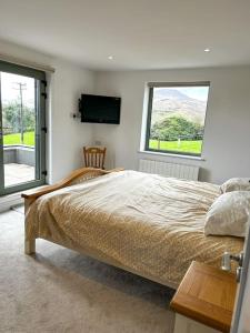 um quarto com uma cama grande e 2 janelas em Sneem Farmhouse em Sneem