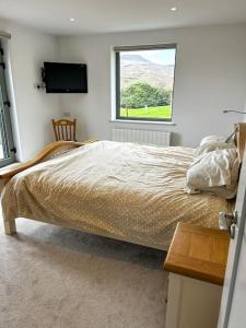 Schlafzimmer mit einem Bett und einem Fenster in der Unterkunft Sneem Farmhouse in Sneem