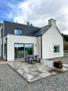 a white house with a picnic table in front of it at Sneem Farmhouse in Sneem