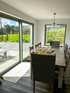 uma sala de jantar com uma mesa de madeira e cadeiras em Sneem Farmhouse em Sneem