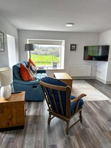 a living room with a blue couch and a chair at Sneem Farmhouse in Sneem