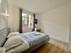 Schlafzimmer mit einem Bett und einem Fenster in der Unterkunft Cosy Appartement Montferrand tout équipé 6prs 27 Languedoc in Clermont-Ferrand