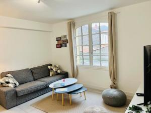 ein Wohnzimmer mit einem Sofa und einem Tisch in der Unterkunft Cosy Appartement Montferrand tout équipé 6prs 27 Languedoc in Clermont-Ferrand