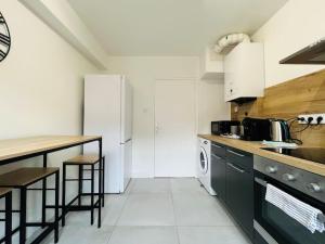 eine Küche mit einem weißen Kühlschrank und einer Theke in der Unterkunft Cosy Appartement Montferrand tout équipé 6prs 27 Languedoc in Clermont-Ferrand