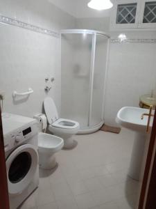 ein weißes Bad mit einem WC und einer Dusche in der Unterkunft Cammini di Sale - inside the Salt Pans WWF Oasis - 5km far from Trapani in Torre Nubia