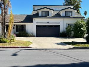 a white house with a driveway and a garage at Private 1bedroom & 1bathroom home perfect for 2+ near Universal studio in Van Nuys