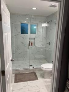 La salle de bains est pourvue d'une douche en verre et de toilettes. dans l'établissement Private 1bedroom & 1bathroom home perfect for 2+ near Universal studio, à Van Nuys