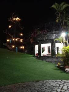 a house with a green lawn at night at Khu nghỉ dưỡng GOOD TIME in Ban Hin Lom