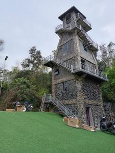 een hoge toren met trappen op een groen veld bij Khu nghỉ dưỡng GOOD TIME in Ban Hin Lom