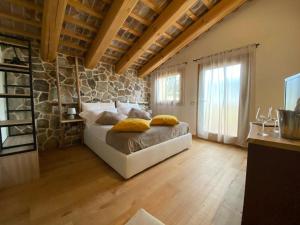 ein Schlafzimmer mit einem Bett und einer Steinwand in der Unterkunft AZIENDA AGRICOLA CA' LUNGA in Cinto Euganeo