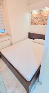 uma cama grande num quarto com uma parede de tijolos em Old town brick apartment em Cracóvia