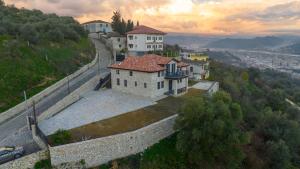 a building on a hill next to a wall at Villa Balliu in Berat