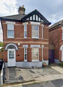 a red brick house with a white door at The Capstone Retreat - Beautiful Detached Family Home By Coastline Retreats, Arcade Machine, Parking, BBQ in Bournemouth