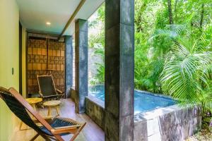 a patio with a hot tub and a table and chairs at Luxurious Oasis Jacuzzi with Art Gallery and Pool in Tulum