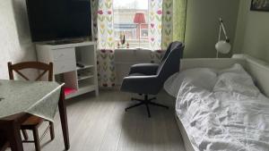 - une chambre avec un lit, une chaise et une table dans l'établissement Rum för övernattning, à Trollhättan
