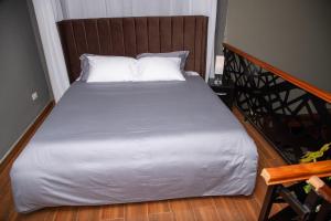 a bed with white sheets and pillows in a room at Malixa Lofts in Wakiso
