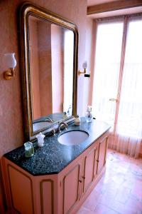 baño con lavabo y espejo grande en CHAMBRES D'HÖTES DANS MAISON DE MAÏTRE DU XVIIIe SIECLE, en Houdan