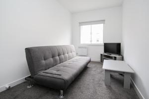 a living room with a couch and a tv at Merchant City Apartment in Glasgow