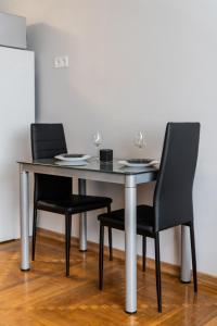 un tavolo e due sedie con bicchieri da vino sopra di Fox studio apartment a Šiauliai