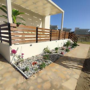 una pared de retención con una valla y un jardín de flores en Sandy Ridge, en Kalamaki