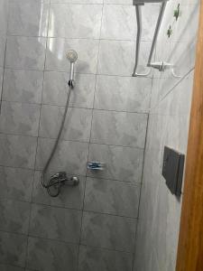 a shower with a shower head in a bathroom at The Pyramid Apart in Kigali