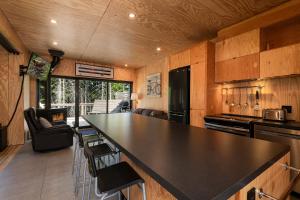 una cocina con un gran mostrador negro en una casa en Les Refuges du Massif de Charlevoix, en Petite-Rivière-Saint-François