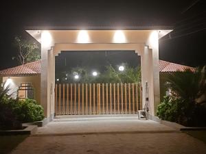 a gate to a house at night with lights at Sreemati - A Tranquil Villa in Shānti Niketan