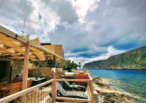 einen Balkon eines Hauses mit Blick auf das Wasser in der Unterkunft Perimenis Seaside House in Yerolimin