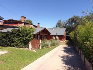 a house with a fence next to a dirt road at El Elyon Duplex in Santa Rosa de Calamuchita