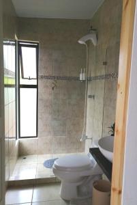 a bathroom with a toilet and a shower and a sink at Villa Buenaventura in San Ramón