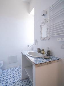 Ponteronico Resort في سيسا أورونكا: حمام أبيض مع حوض ومرآة