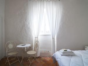セッサ・アウルンカにあるPonteronico Resortのベッドルーム1室(ベッド1台、テーブル、椅子付)