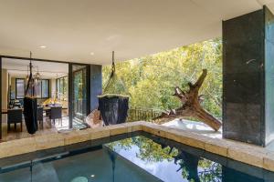 a swimming pool in a house with a large window at Luxurious Oasis Jacuzzi with Art Gallery and Pool in Tulum
