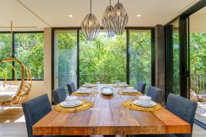 a dining room with a wooden table and chairs at Luxurious Oasis Jacuzzi with Art Gallery and Pool in Tulum