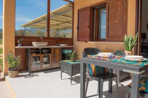 eine Terrasse mit einem Tisch und Stühlen sowie eine Küche in der Unterkunft Beth la Casa della Luna in Annunziata