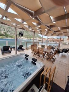 a hot tub on a deck with a table and chairs at Perimenis Seaside House in Gerolimenas