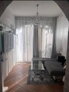 uma sala de estar com uma mesa de vidro e um lustre em Casa di vacanza "San Nicola" em Olbia