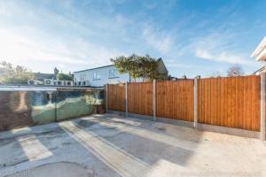 a wooden fence in front of a building at 2 Bed with garden, for 5 guests in Forest Hill