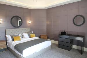 a bedroom with a bed and a desk and mirrors at Ponsbourne Park in Hertford