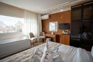 een slaapkamer met een bed, een bad en een televisie bij Tuya Pyramids Inn hotel in Caïro