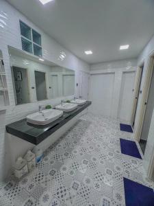 a bathroom with two sinks and two mirrors at Ratchadadome hostel in Bangkok