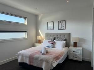 Geelong Luxury Beach K Villa في North Shore: غرفة نوم بسرير كبير ونافذة