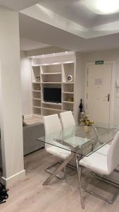 comedor con mesa de cristal y sillas blancas en Apartamento en San Mames, en Bilbao