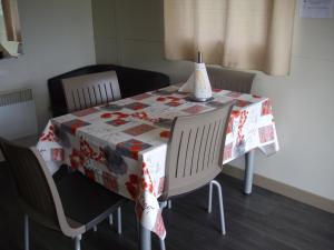 mesa de comedor con mantel rojo y blanco en Belles vacances aux chalets en Casteljaloux