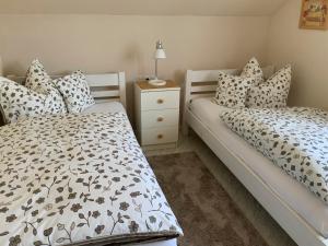 a bedroom with two beds and a night stand at Annes Ferienwohnung Freiburg in Vörstetten