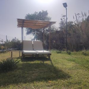 una silla blanca sentada bajo un dosel en la hierba en Sandy Ridge, en Kalamaki